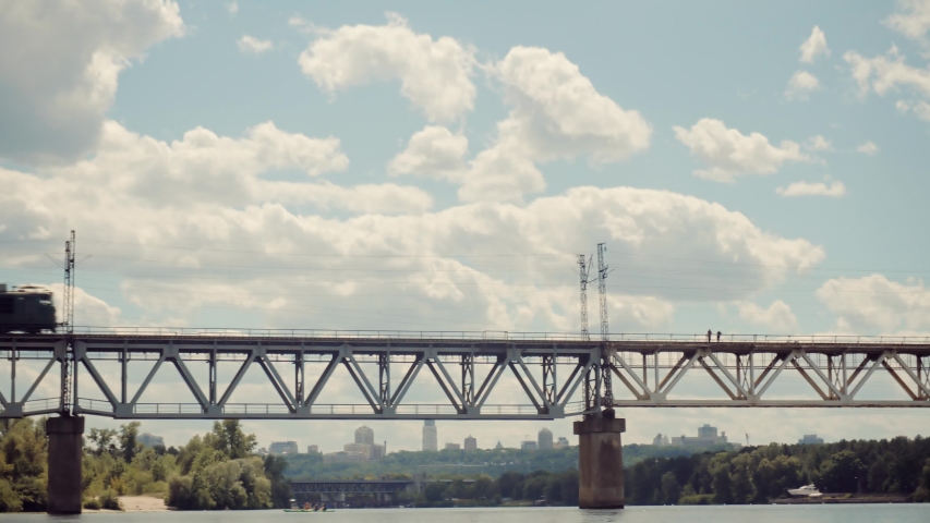 Cargo Train Moving On Railroad Bridge. Kiev City Bridge. Freight Train Passing Railroad Delivery. Electric Locomotive With Wagons Rides On Steel Railway. Heavy Container Industry Train Transportation  Royalty-Free Stock Footage #1056540158