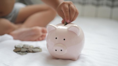 Family putting coins into piggy bank for the future savings.