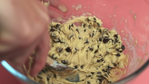 Making and Mixing Chocolate Chip Cookies dough in a transparent glass bowl in 4K. Concept of Preparing Chocolate Chip cookies step by step.