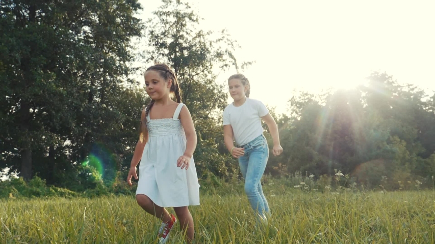 children kid dream together run in the park at sunset. happy family people in the park concept. two sisters playing catch-up run. baby child fun running in green meadow. happy family kid dream concept Royalty-Free Stock Footage #1056548141