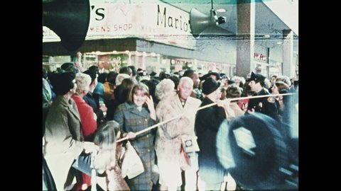 1960s Oregon: Robert F. Kennedy walks through crowd at mall, shakes hands with people.