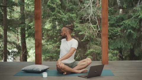 Freelance business man warming up and practice yoga workout online with teacher web course on laptop. New app for self care and healthy body. Quarantine training routine.
Mindfulness lifestyle