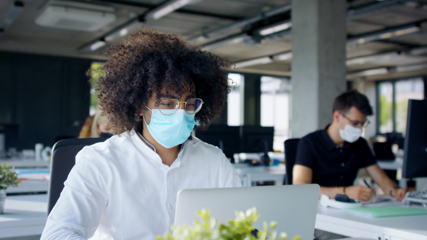 Young people with face masks back at work or school in office after lockdown. Royalty-Free Stock Footage #1056564515