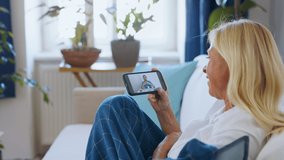 Senior woman with smartphone at home , consulting doctor and video call concept.