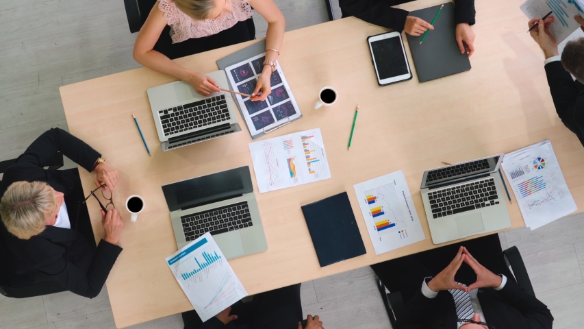 Business people group meeting shot from top view in office . Profession businesswomen, businessmen and office workers working in team conference with project planning document on meeting table . Royalty-Free Stock Footage #1056565079