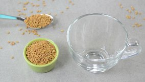 Fenugreek tea in a glass cup with fenugreek seeds in a cup