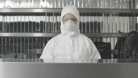 Concentrated serious woman in antiviral suit and respirator spraying sanitizer in gym and cleaning surface. Caucasian employee in protective eyeglasses and gloves rubbing furniture with disinfectant. - Powered by Shutterstock - Get 15% off with code: PIKWIZARD15