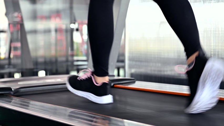 Sporty woman workout and running in machine treadmill. Asian woman exercise and lifestyle at fitness gym. Wellness and healthy for bodybuilding. | Shutterstock HD Video #1056578696