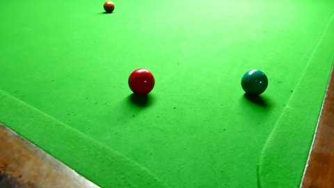Close up of Snooker shooting on snooker table. Game of snooker. billiard/snooker ball getting knocked into corner pocket, coming into focus