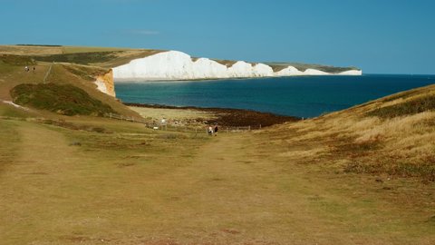 Slow motion walk towards the impressive Seven Sisters, an iconic chalk cliff formation opposite Cuckmere Haven, Sussex, England, UK
