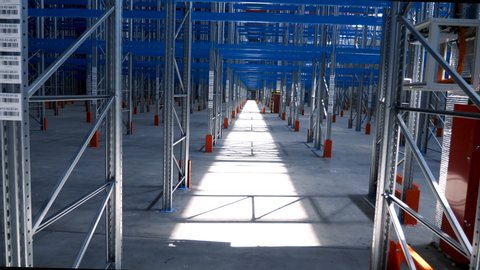 Wide View Empty Warehouse With Metal Shelves. Large Modern Industrial Building From The Inside With Rows Of Racks. Big Steel Structures of Pallet Frame in the Sorting Center of Logistics Company 4k