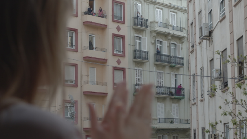 VALENCIA, SPAIN - APRIL 25, 2020: Covid-19 quarantine. People staying home and coming to the balconies together to express support and thanks to medical workers during coronavirus pandemic | Shutterstock HD Video #1056584444