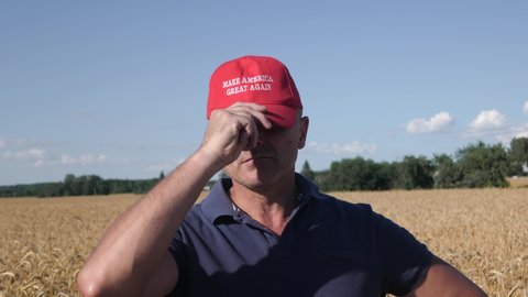 Belarus, Minsk, June 2020. Portrait of mature man in the wheat field wearing a MAGA hat. Field of golden wheat right behind farmer trump supporter
