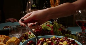 Close up shot of table covered with healthy vegan mediterranean food. People filling up their plates and glasses at dinner party table low angle 4k footage