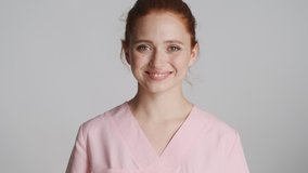 Young beautiful confident doctor happily looking in camera and smiling over white background