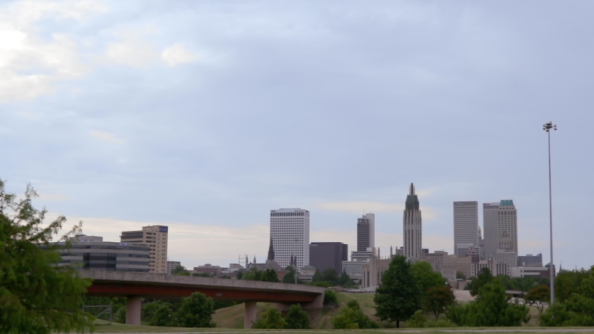 Tulsa, Oklahoma Skyline. Daylight. Bridge in the foreground and cityscape in the background.