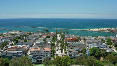 Aerial view of Corona Del Mar in Newport Beach, Orange County California on a sunny day with palm trees the ocean or coast below.