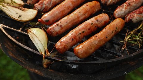Grilling sausages on a cast iron grill outdoors close up view