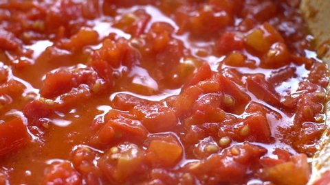 Tomato sauce. 
Pan Left. Close up. Slow motion.
Boiling tomato sauce made from chopped fresh ripe tomatoes.
Italian cuisine.