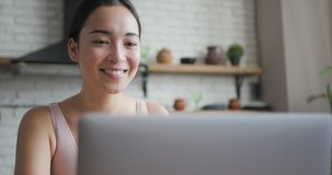 Close up portrait of healthy asian woman talking on a video call on laptop and smiling