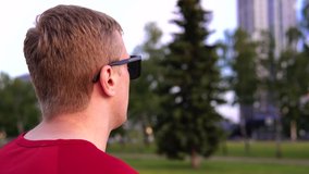a young blond guy uses smart glasses. raw footage for subsequent insertion of graphics. New interesting gadgets and devices. The growing world of electronics.