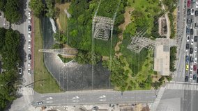 Drone move forward of electricity pylons network and city public park greens. Map view of electric pylon tower with the cityscape city street in Shanghai China. Industry and technology concept footage