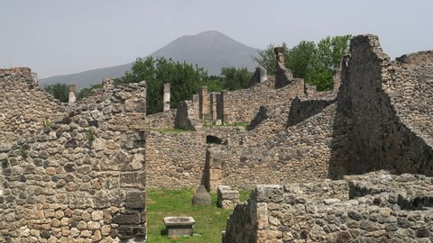 NAPLES, ITALY- JUNE, 13, 2019: walls of building ruins at pompeii with mt vesuvius in the distance
