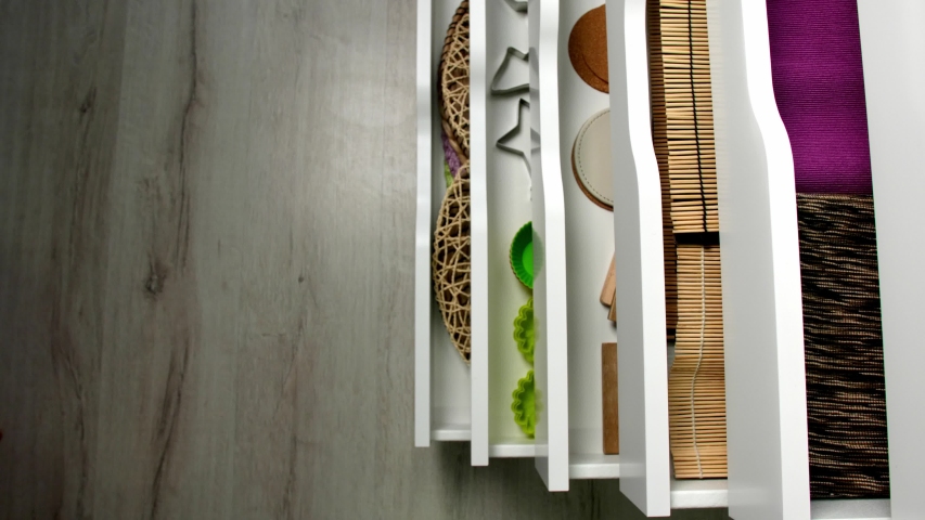 Closing of chest of drawers with different kitchen utensils, top view