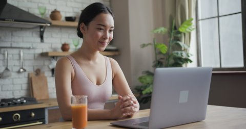 Close up portrait of healthy asian woman talking on a video call on laptop, side view 스톡 비디오