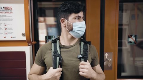 Caucasian man in olive shirt with green backpack with mask waiting train virus still waiting medium shot : vidéo de stock