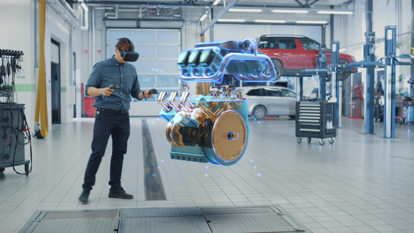 Car Service Manager Uses a Futuristic Virtual Reality Headset Diagnostics Gadget with Controllers. Specialist Inspecting the V6 Internal Combustion Engine for Parts and Component Numbers. | Shutterstock HD Video #1056636911