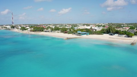 Grand Turk Island in the Turks and Caicos Archipelago on a sunny day. Aerial pullback over the ocean and beach