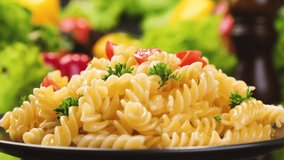 Plate of italian fusilli pasta with tomatoes and basil leaves, 4K UHD video footage