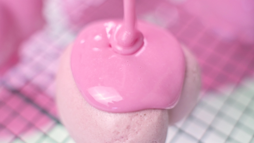 Pink glaze frosting is poured onto the frozen pink cake in the shape of a heart. Homemade cakes, close up, macro | Shutterstock HD Video #1056644594