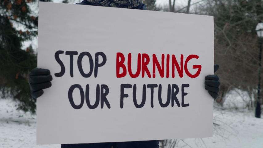 Stop Burning Our Future shot, Person Protest Man Stands in Park With Big White Poster Royalty-Free Stock Footage #1056645833