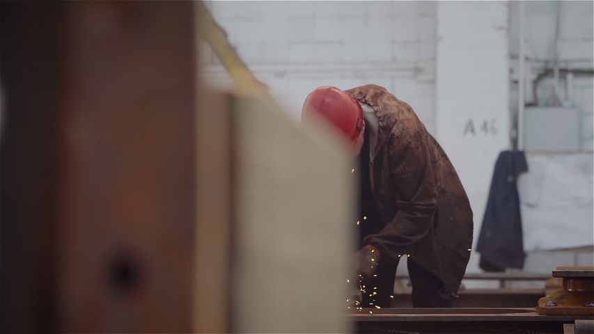 Factory Worker Grinds Metal Construction using angle grinder. Bright Golden Sparks comes out, Heavy Manual Work at Modern Steel Making Industry. Slow Motion.  | Shutterstock HD Video #1056645845