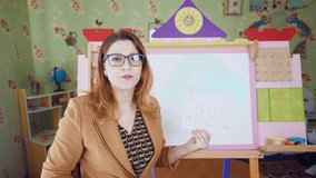 A young woman teacher talks about new geometric shapes. Homeschooling. A preschool teacher conducts an online lesson. Children distance education. E-learning. 