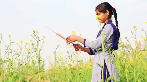 Rohtak, Haryana, India - 12 January, 2020:  Teenager girl blowing dandelion seeds outdoor in nature during springtime.