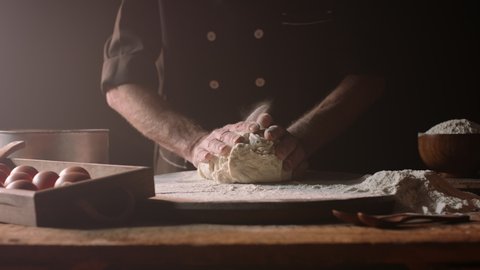 Senior professional chef kneading floured dough at bakery, mature retiree enjoying hobby making homemade bread using traditional recipe isolated on black background close up 4k footage