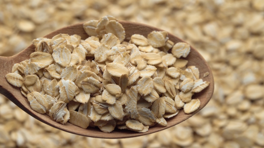 Oatmeal in spoon. Oat flakes. Close-up rotating. Dry oat flakes grains background, close up rotation loopable 4k top view. Food background. Gastronomy concept, organic food. Macro rotation oat flakes. Royalty-Free Stock Footage #1056658904