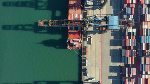 Drone shot of modern industrial port with containers from top view or aerial view. It is an import and export cargo port where is a part of shipping dock
