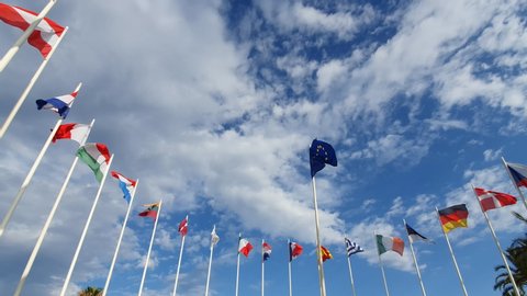 Flag of European Union and EU member flags on the background against a cloudy sky