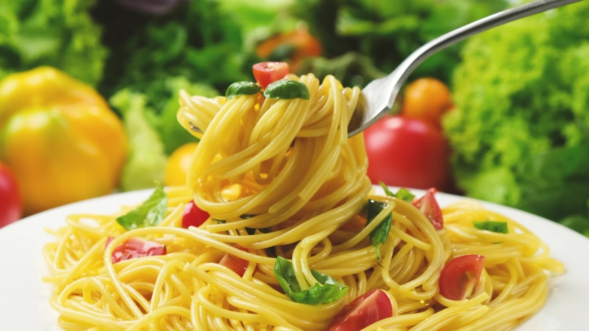 Plate of cooked italian pasta, spaghetti on fork with tomatoes and basil leaves, 4K UHD video footage | Shutterstock HD Video #1056665045