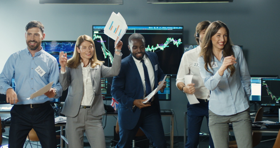 Cheerful young males and female mixed-races brokers dancing and having fun with documents in hands after successful trading day. Multiethnic men and women traders celebrating. Success celebrate. Royalty-Free Stock Footage #1056665360