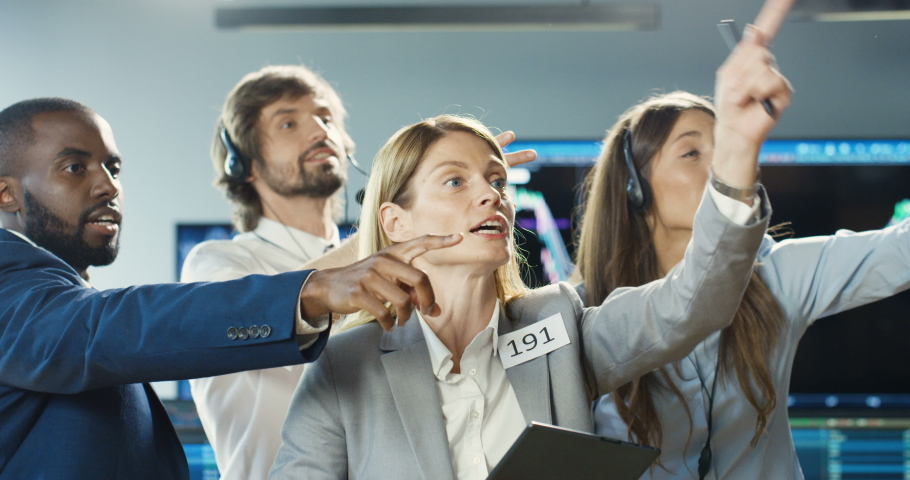 Mixed-races males and females traders selling and buying at stock market on trading floor at exchange. Change office. Multiethnic men and women screaming and shouting when putting rates. Royalty-Free Stock Footage #1056665369