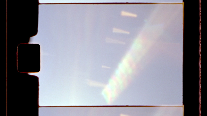 Super 8 frame authentic film scan with sprocket hole and dynamic sun lens flare. Great for overlays for the vintage retro look for digital footage. With authentic camera sound. Royalty-Free Stock Footage #1056665528