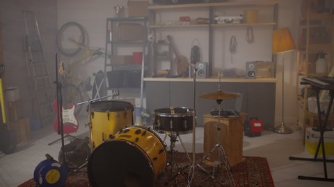 Slow motion shot footage of young adult man wearing casual clothes bringing and setting drum plates