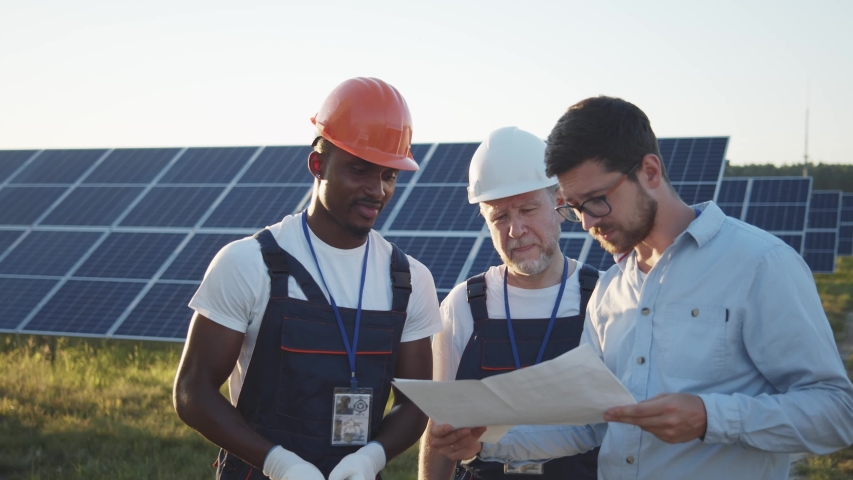 Chief engineer and multi-ethnic specialists learning the report of investment for solar plant construction. Business team. Negotiation. Clean energy. Industry. Royalty-Free Stock Footage #1056680387