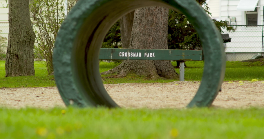 Crossman Park in Ortonville, Michigan. Playground bench seen through a concrete tube.