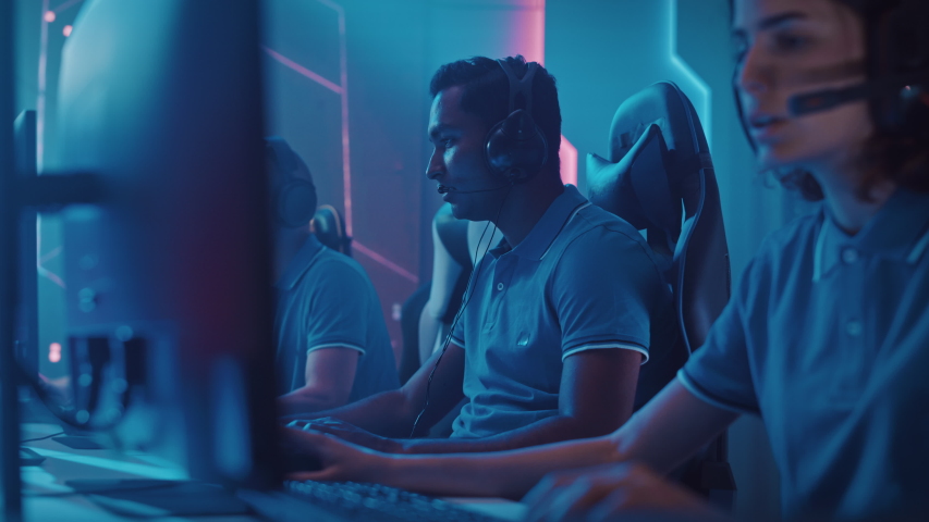 Diverse Esport Team of Pro Gamers Playing in Video Game, use Headsets to Talk, Win Championship and Celebrate with High-Five. Stylish Neon Cyber Games Arena. Online Broadcasting of Tournament Event Royalty-Free Stock Footage #1056687293